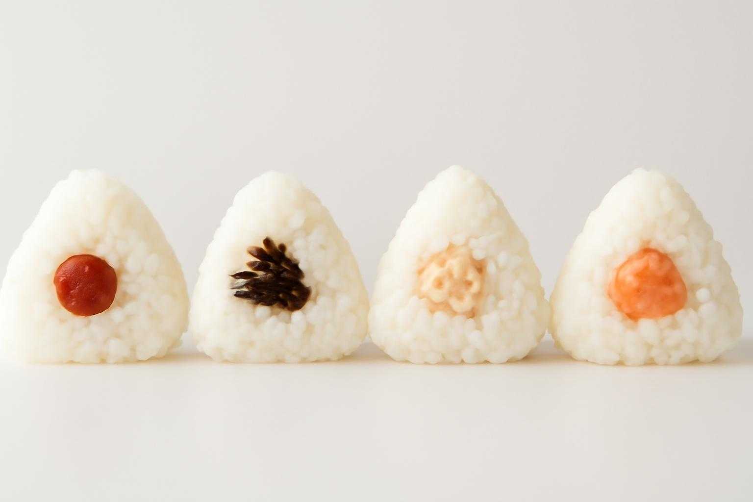 梅干し、昆布、ツナマヨなど異なる具材のおにぎりが並んでいる様子