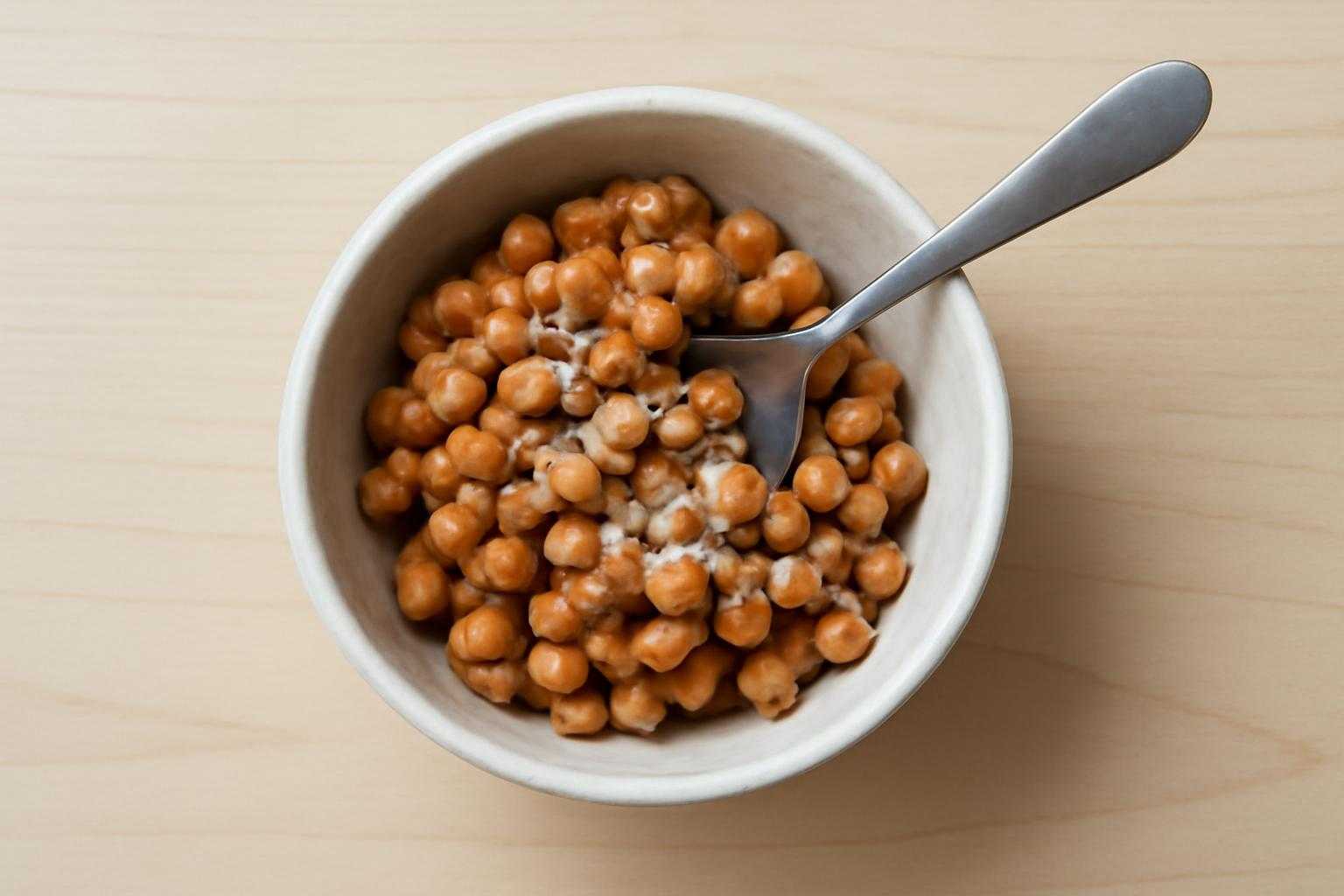 納豆をスプーンで混ぜながら白い粒をチェックしている調理の様子